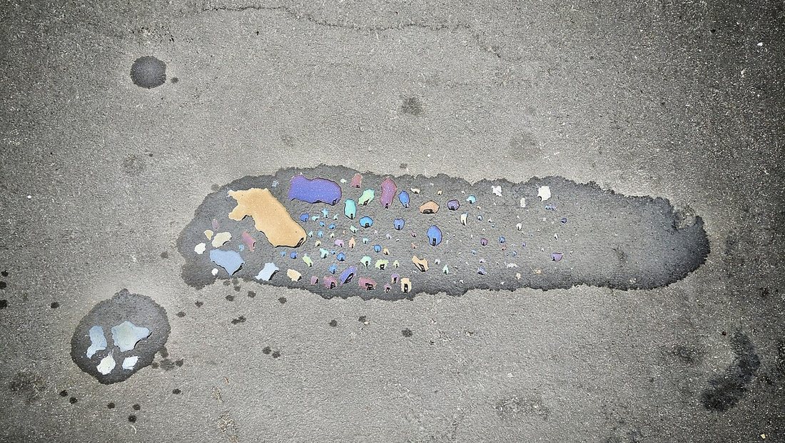 An oil stain on a concrete driveway being treated